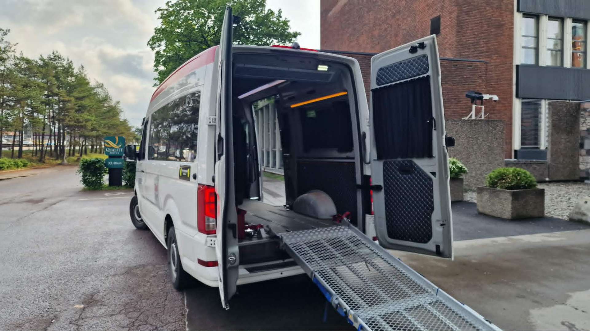Minibuss med åpne bakdører og rampe ute
